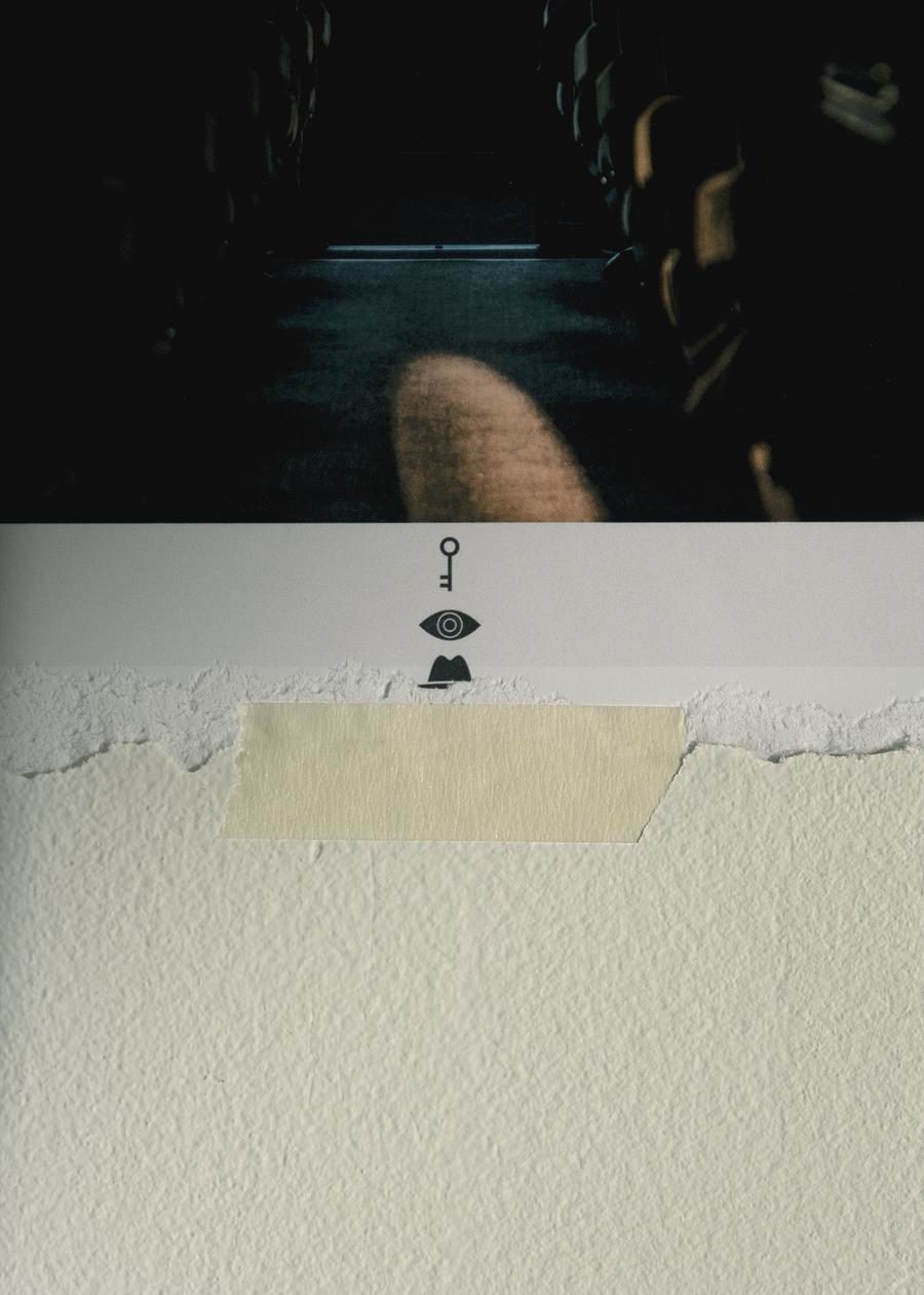 Close-up of The Portal Hotel installation materials including a key, eye, and hat icon on torn paper